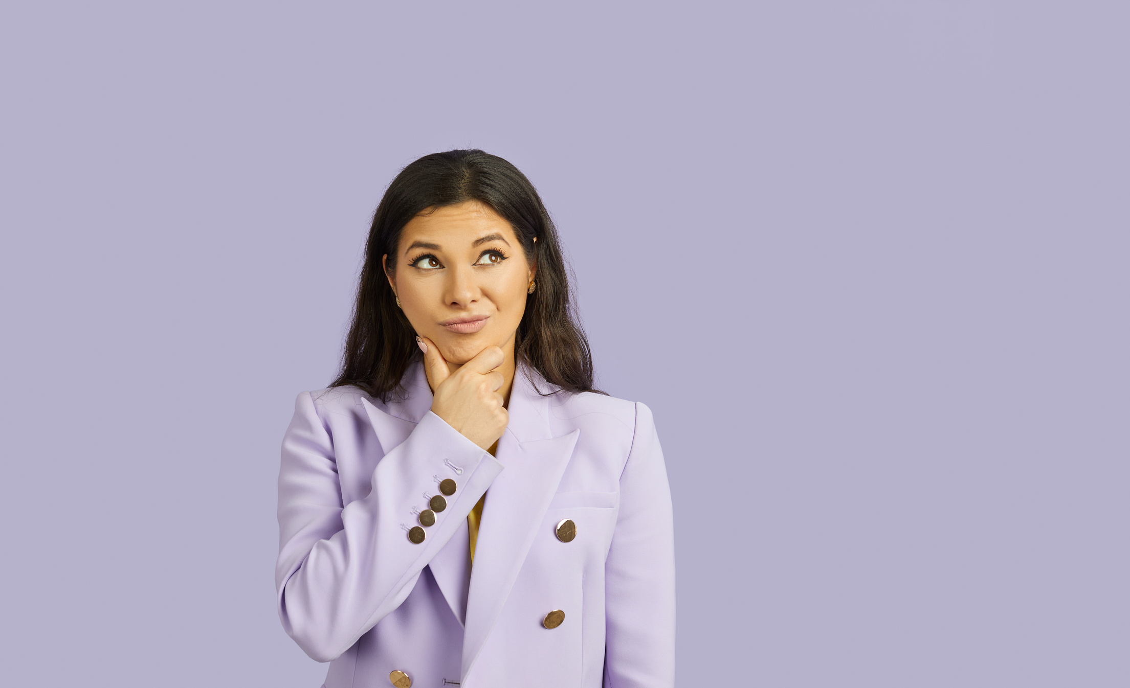 Portrait of Beautiful Woman with Doubtful Facial Expression Isolated on Pastel Purple Background.